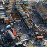 Aerial view of severe coastal town damage after Hurricane Melissa, showing widespread destruction, debris, and flooding across residential and commercial buildings. Black River Jamaica