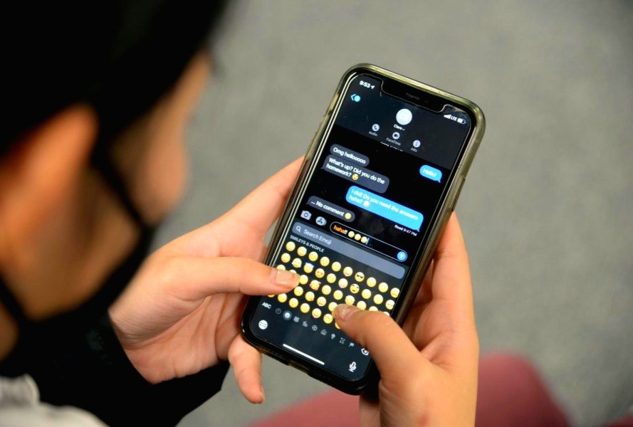 A person holding a smartphone while texting in a messaging app, illustrating common texting mistakes in a romantic relationship. The screen shows a conversation bubble with emojis, highlighting digital communication habits that can lead to relationship silence or ghosting. Perfect for identifying bad texting habits that ruin love and romance.